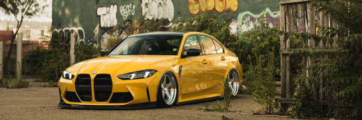 Yellow BMW G80 M3 bagged on Bag Riders Super Low Air Suspension
